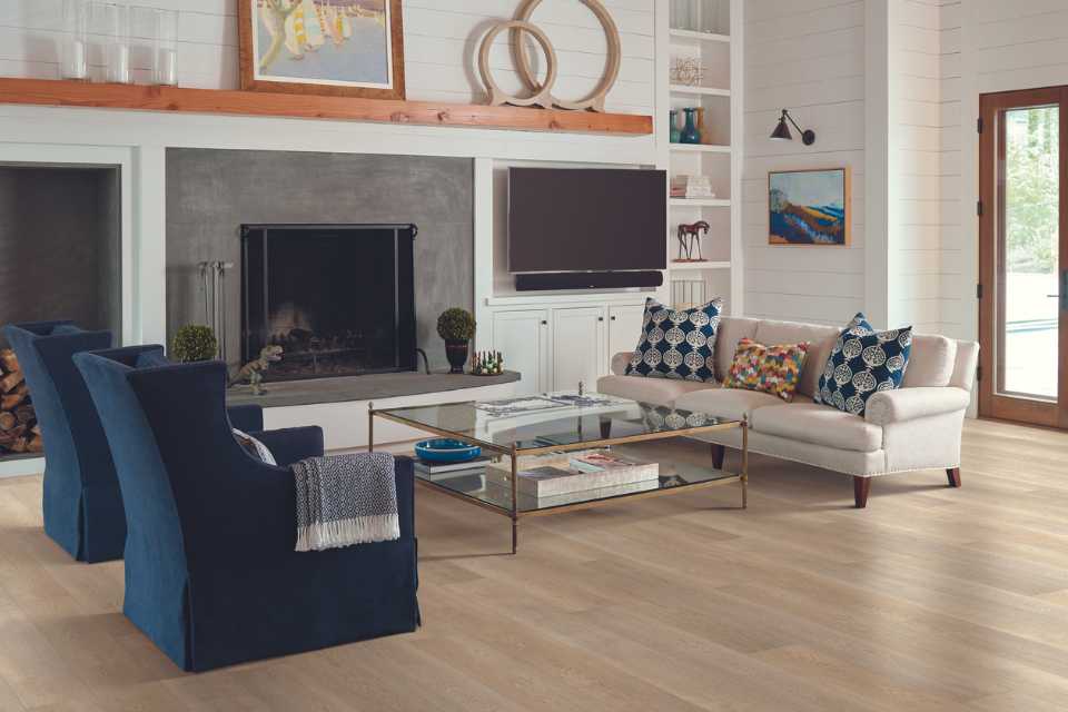 white oak look luxury vinyl in modern living room with blue accents, fireplace and shiplap walls